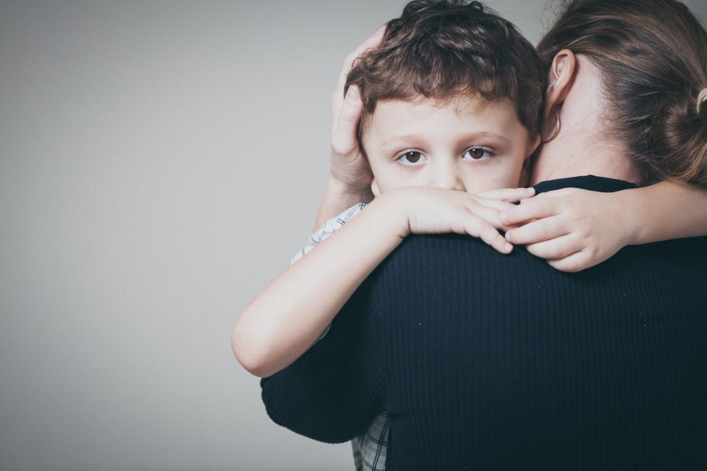 A parent hugging their child after an honest conversation about their divorce.